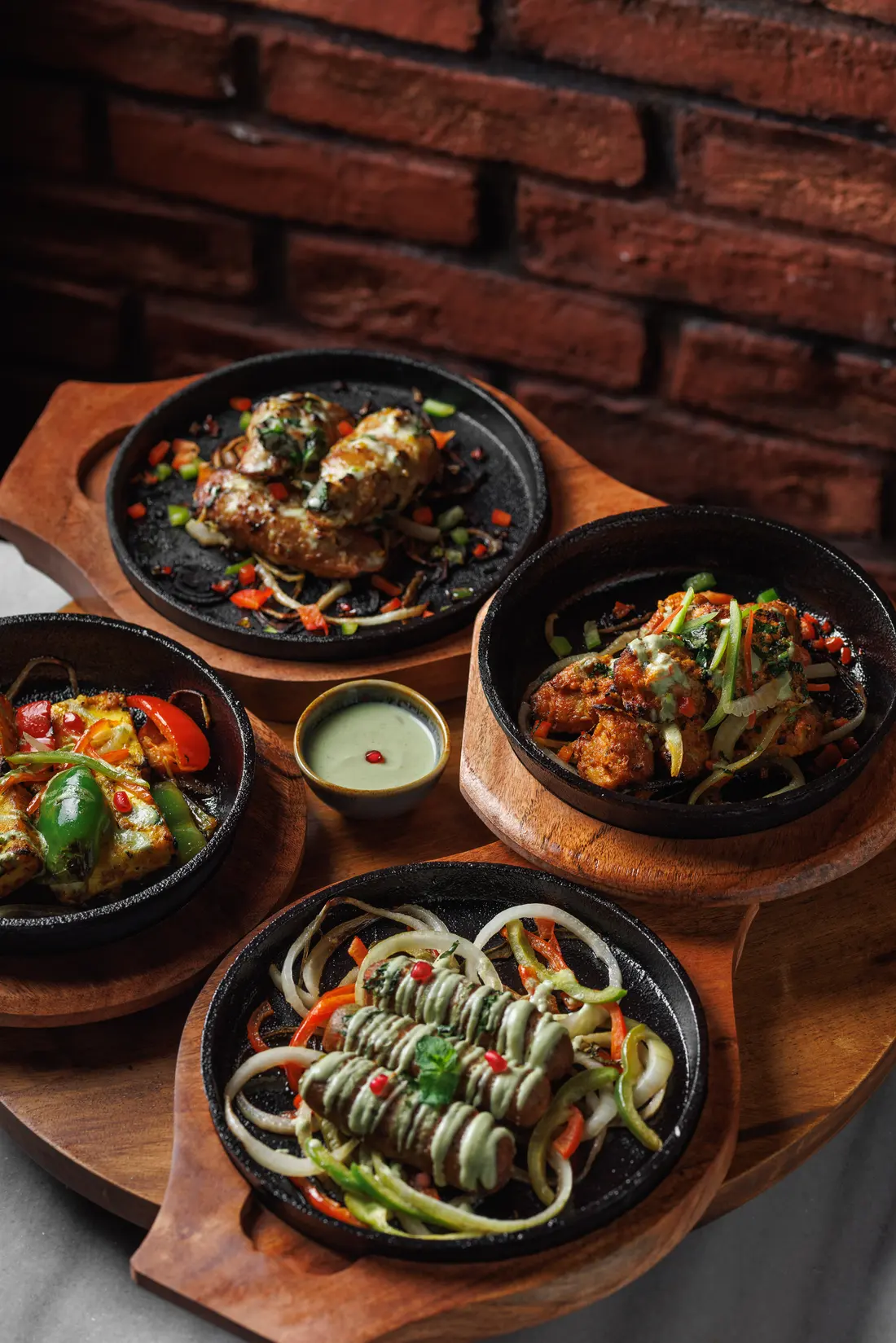 Padharo's winter sizzlers on a wooden board: seekh kebab, afghani malai chaap, chick'n tikka and paneer tikka